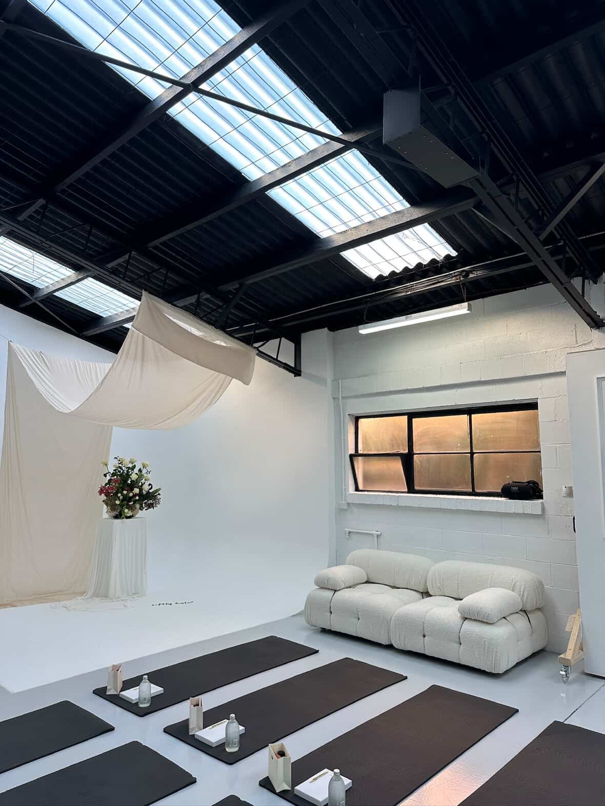 Editorial Haus styled for a private event with draped fabric, florals and yoga mats laid out
